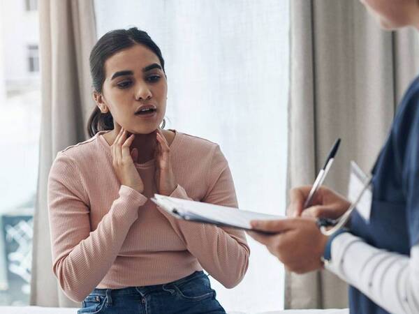 A young woman discussing her concerns with a provider in a clinic, illustrating an appointment at a Scripps HealthExpress location.