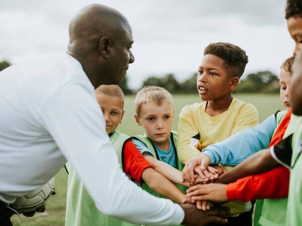 A soccer coach  gets his kids ready to play.