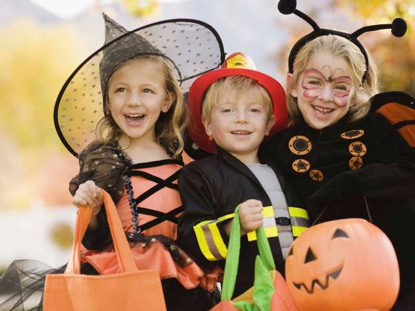 Group of kids dressed for Halloween getting ready to trick or treat.