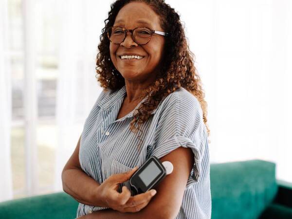 An African-American woman uses a device to monitor her blood glucose and keep her diabetes in check.