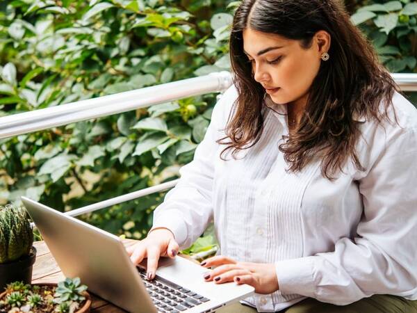 A young heavyset woman researches gastric sleeve surgery on her laptop computer as she is considering the weight-loss procedure.