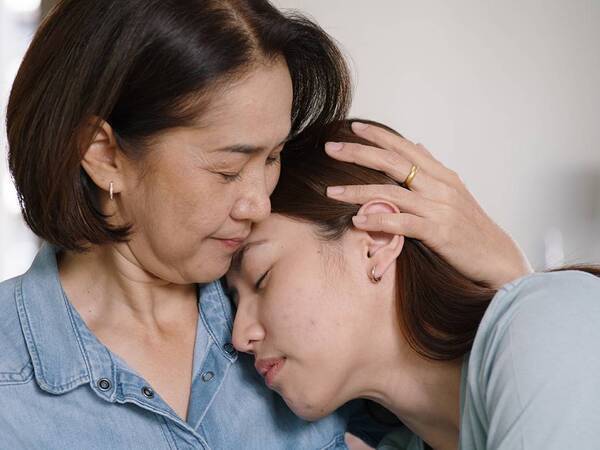 A mother comforts her teenager daughter who has depression.