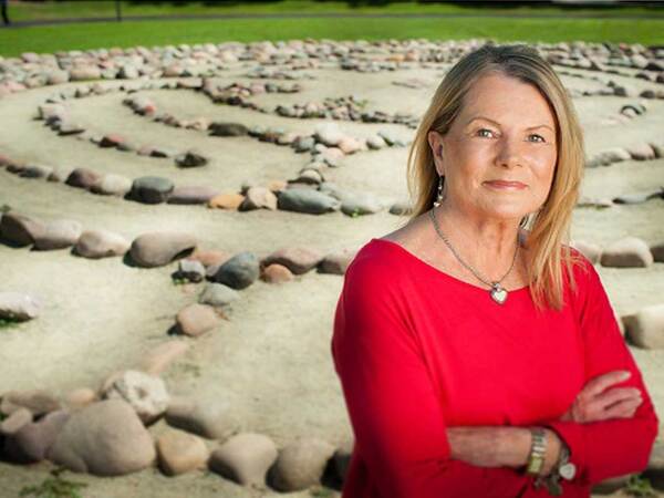 Portrait of heart patient and advocate Susan Iliff with meditation labyrinth in the background. 