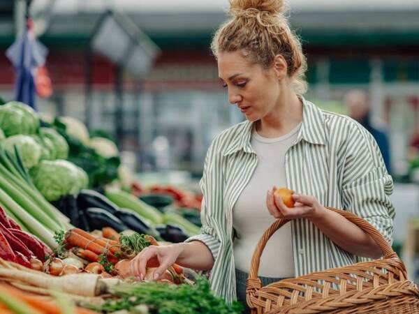 A woman shops for fresh produce at farmers market.