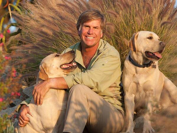Wildlife photographer Roy Toft, who had two hip replacement surgeries at Scripps Health, sits with his two dogs.