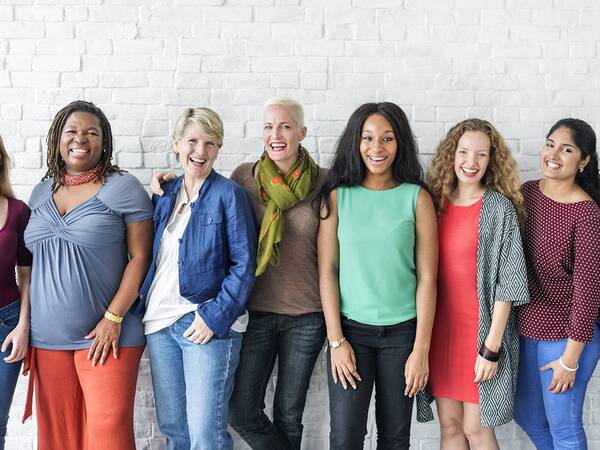 Diverse group of women in line and smiling. 