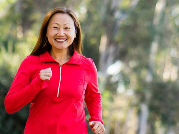 Personal trainer Christine Burke runs in a San Diego park after hip replacement surgery at Scripps relieves her chronic hip pain.