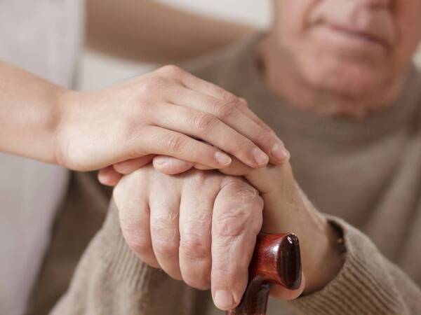 Melisa Houser, MD, of Scripps Clinic discusses FDA-approved Parkinson's disease drug with the Union-Tribune. Photo posted shows elderly man with Parkinson's disease receiving care.