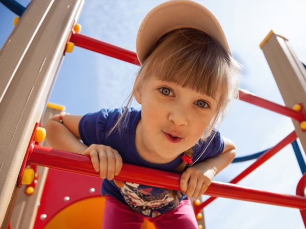 A child smiles while in playground. Parents are encouraged to assure their child's playground is safe enough to play to avoid preventable injuries.