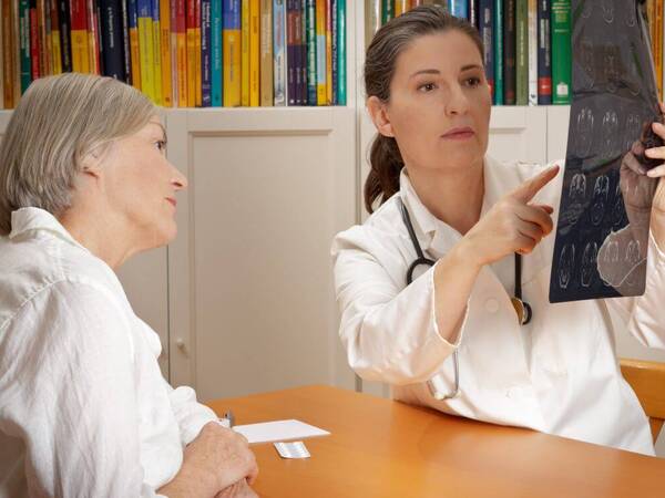 A female doctor explains the results of a CT scan with a stroke patient.