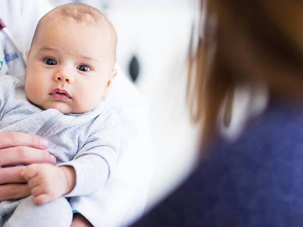 A baby is held by a Scripps HealthExpress Rancho Bernardo provider.