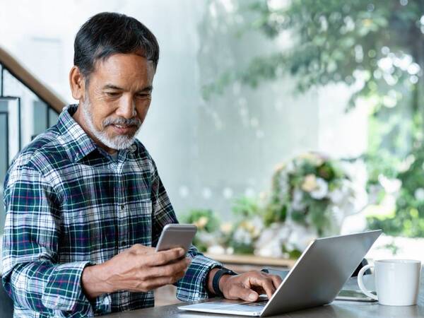 A Hispanic man with diabetes uses his smartphone to receive text messages on diabetes management.