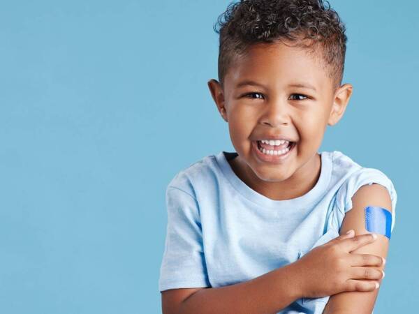 A measles vaccinated preschooler massages his arm.