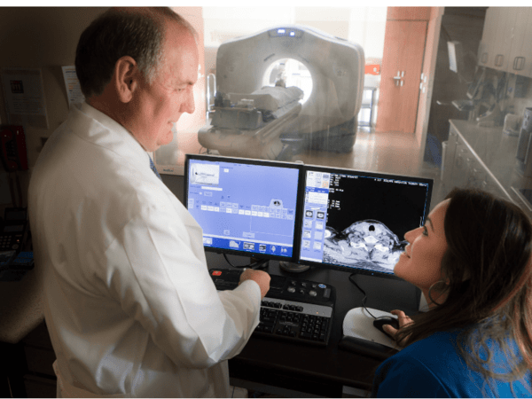 Thomas Buchholz, MD, medical director of Scripps MD Anderson Cancer Center, goes over instructions with an oncology nurse before a patient receives CAT scan.