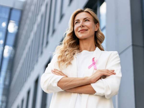 Woman wearing a pink ribbon for breast cancer awareness.