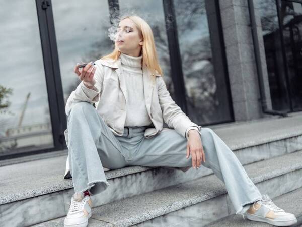 A young woman vapes nicotine, unaware of the health risks.