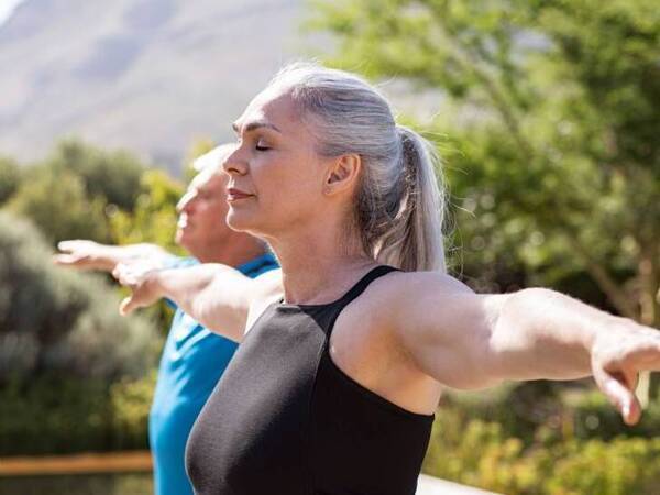 Mature group of adults stretching before they begin exercising. 