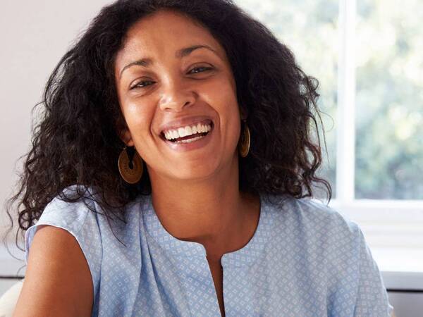 A woman in her 40s smiles as she enters perimenopause. 