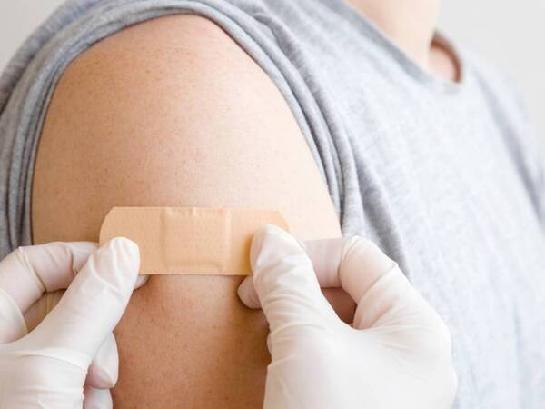 A band aid is placed over arm where vaccination injections for flu, COVID and RSV was given.