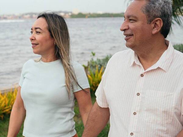 An older couple enjoy a stroll by the water with less back pain thanks to a new minimally invasive procedure.
