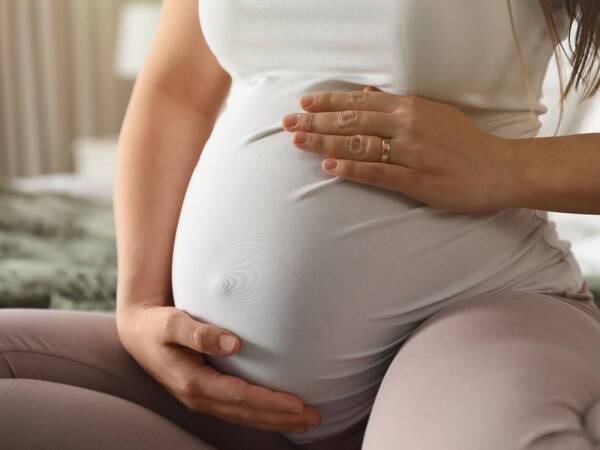A pregnant woman feels her stomach after vaginal discharge.