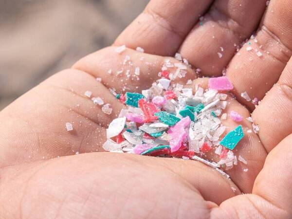 Microplastic pieces in the palm of a person's hand.