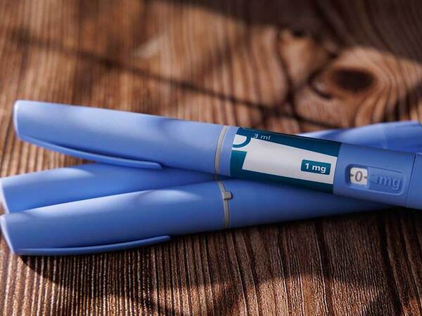 Three blue GLP-1 doses grouped together, illustrating the packaging each dose comes in.