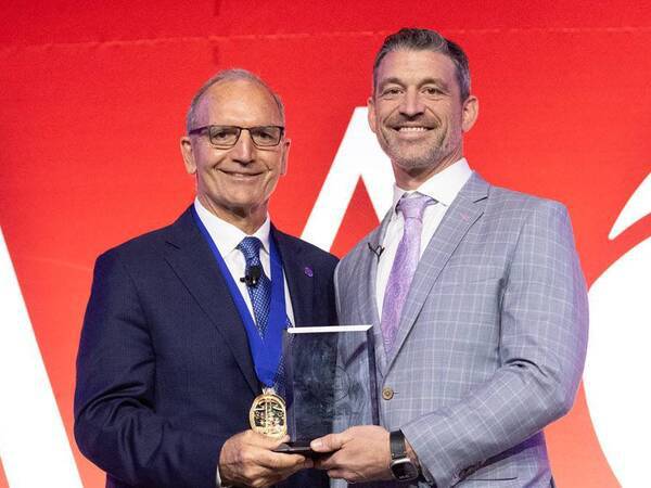 Gregory Mundis, MD, (right) receiving the AAOS 2026 Humanitarian Award during the group’s annual conference in New Orleans. Courtesy of AAOS 