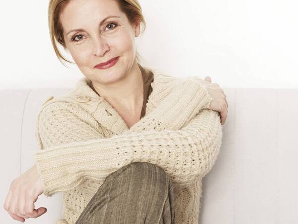 A smiling middle-aged woman represents the empowerment that comes with understanding your breast cancer diagnosis.