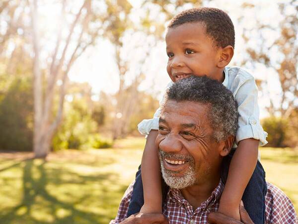 A mature African-American man with grandson represents the power and value of knowing prostate cancer symptoms.