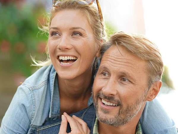 A smiling young Caucasian couple represent the full life that can be led after cancer screening and treatment.