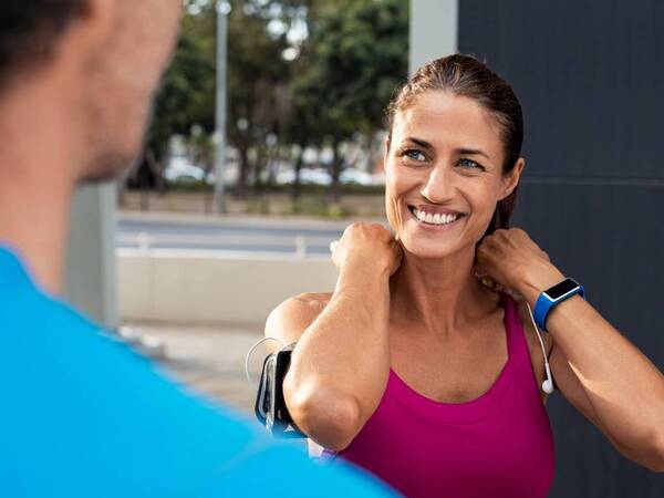 A middle-aged woman wearing a fitness tracker and workout clothes represents people treated for cardiomyopathy at Scripps.