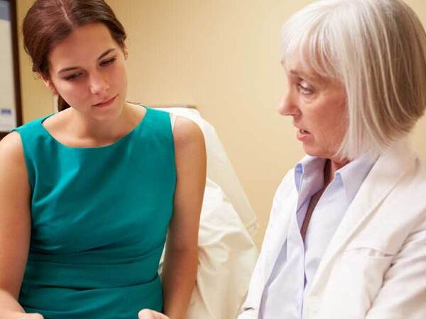 A patient consults with her plastic surgeon in a clinical environment