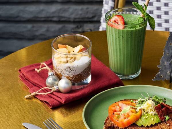 Avocado toast, vanilla chia seed pudding and a tropical smoothie set on a festive holiday decorated table.