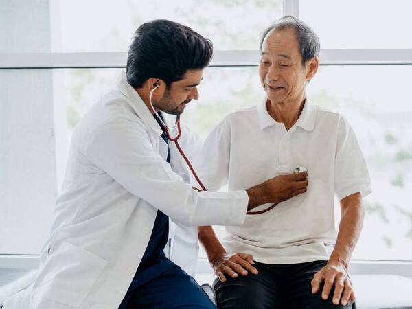 A male physician and a male patient discussing the patient's health, illustrating a Medicare annual wellness visit.