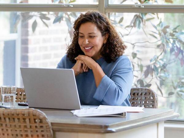 A female patient uses her computer to look at online appointments for her doctor appointment.