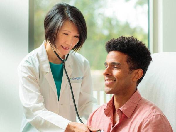 Dr. Siu Ming Geary, MD, Primary Care physician for Scripps Clinic treating a patient in a clinical office.