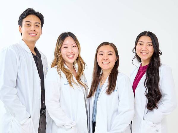 Four pharmacy residents take a group photo wearing their lab coats at Scripps La Jolla.