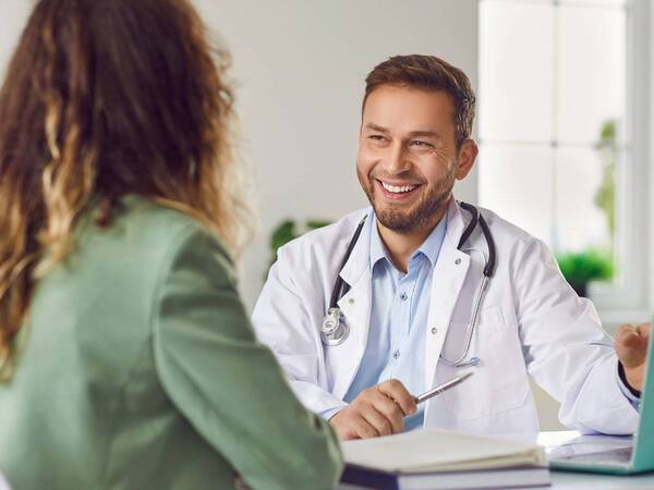 A physician talks with a patient, representing common questions about Scripps Center for Executive Health.