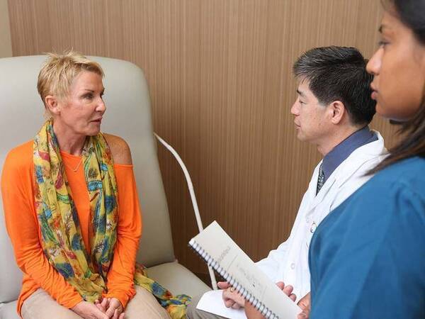 A middle-aged woman talks to a Scripps radiation oncology team, representing what happens before, during and after radiation treatment.