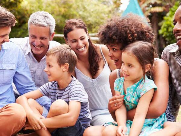 Friends and family gather for a smiling moment in a casual outdoor environment