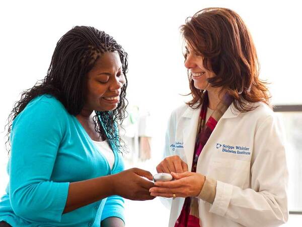 A patient with diagnosed with diabetes shares a friendly conversation with a Scripps researcher as part of a clinical study. 
