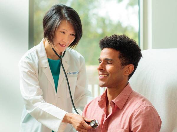 Dr. Siu Ming Geary, MD, Primary Care physician for Scripps Clinic treating a patient in a clinical office. 