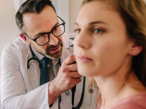 A female patient undergoes a hearing exam.