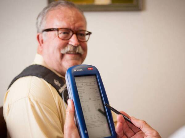 A middle-aged man sits with a medical professional during DBS, a treatment for Parkinson's symptoms.