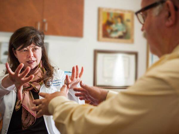 Scripps neurologist Dr. Melissa Houser assesses a man for  hand tremors related to Parkinson's disease, representing the expert, compassionate care received at Scripps.
