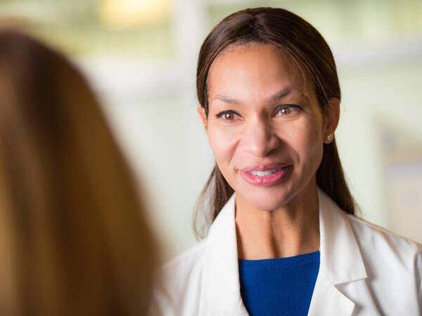 Dr. Rio Dickens-Celestin, MD, Scripps Clinic Internal Medicine physician smiling while discussing treatment with a patient.