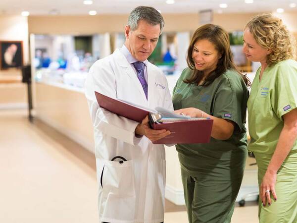 Three Scripps Health kidney transplant experts having a discussion in a medical facility waiting area.