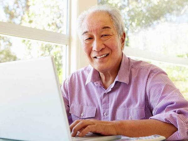 A smiling mature Asian man represents the full life that can be led after stomach cancer treatment.