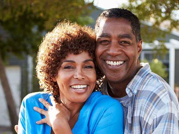 A smiling middle-aged African-American couple represents the full life that can be led after treatment for head and neck cancer.